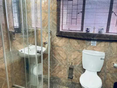 a bathroom with a toilet and a sink at Ivory Sands Selfcatering house in Marloth Park