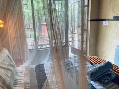a room with a window with curtains and a bed at Ivory Sands Selfcatering house in Marloth Park