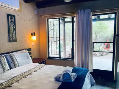 a person laying on a bed in a room with a window at Ivory Sands Selfcatering house in Marloth Park
