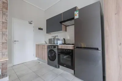 a kitchen with a stainless steel refrigerator and a dishwasher at Alimama Spaces: The Manson's Green Creek Studio in Pretoria