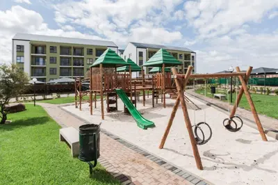 a park with playground equipment in front of a building at Alimama Spaces: The Manson's Green Creek Studio in Pretoria