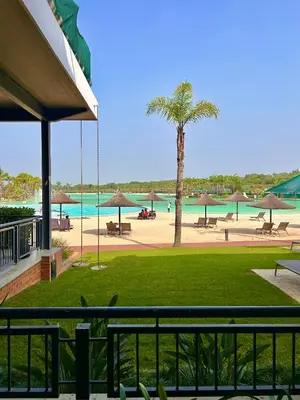 a view of a beach with a palm tree at 1152 @The Blyde Riverwalk - Crystal Lagoon in Pretoria