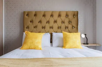 a bedroom with a large bed with yellow pillows at Alimama Spaces: The Manson's Green Creek in Pretoria