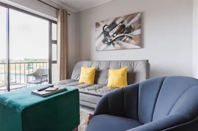 a living room with a couch and a table at Alimama Spaces: The Manson's Green Creek in Pretoria