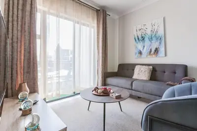 a living room with a couch and a table at #Alimama Spaces The Fountain Blyde in Pretoria