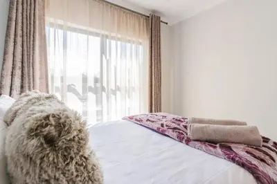 a bedroom with a bed with a large window at #Alimama Spaces The Fountain Blyde in Pretoria
