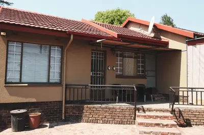 a house with a porch with a roof at Koemi Guest House in Kempton Park