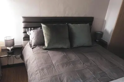 a bed with several pillows on it in a bedroom at Koemi Guest House in Kempton Park