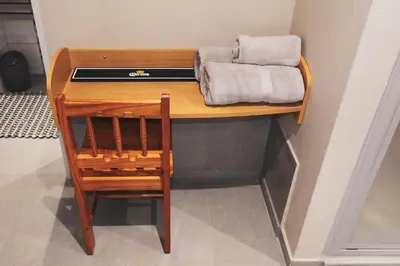 a wooden desk with a chair and towels on it at Koemi Guest House in Kempton Park