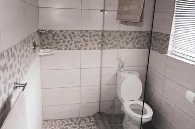 a bathroom with a toilet and a sink at Koemi Guest House in Kempton Park