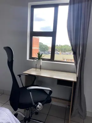 a desk and a chair in front of a window at Centurion Fully furnished lock up&go 1 bedroom apartment in Centurion