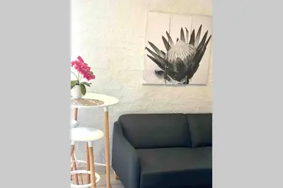a living room with a blue couch and a table at Centurion Fully furnished lock up&go 1 bedroom apartment in Centurion