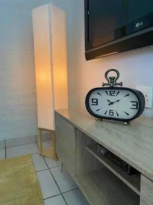 a clock sitting on top of a table at Centurion Fully furnished lock up&go 1 bedroom apartment in Centurion