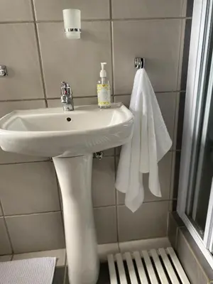 a bathroom with a white sink and a towel at Centurion Fully furnished lock up&go 1 bedroom apartment in Centurion