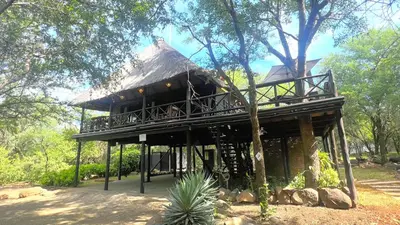 a building with a thatch roof on top of it at Kruger Kumba - Lahlekile Nathi in Marloth Park