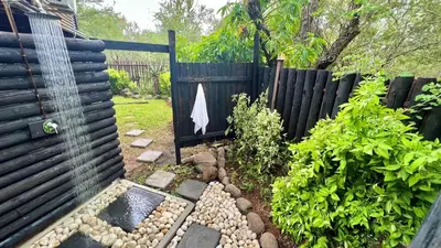 a backyard with a fence and a garden with plants at Kruger Kumba - Lahlekile Nathi in Marloth Park