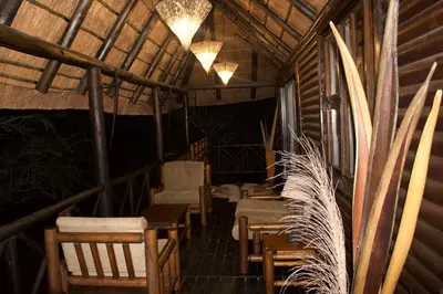 a room with chairs and tables in a cabin at Kruger Kumba - Lahlekile Nathi in Marloth Park
