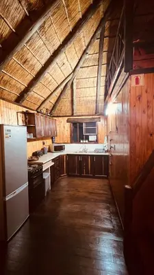 a kitchen with wooden cabinets and a white refrigerator at Kruger Kumba - Lahlekile Nathi in Marloth Park