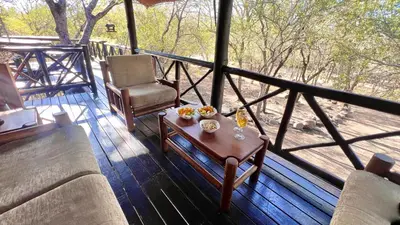 a porch with a couch and a table and a chair at Kruger Kumba - Lahlekile Nathi in Marloth Park