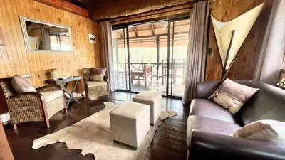 a living room with a couch and a table at Kruger Kumba - Lahlekile Nathi in Marloth Park