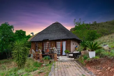 a small hut with a thatched roof at PAPPAS in Pelindaba