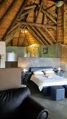 a large bedroom with a bed and a couch at PAPPAS in Pelindaba
