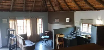 a kitchen with a table and a desk and two windows at PAPPAS in Pelindaba
