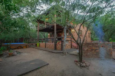a brick building with a tree in front of it at Inkwazi Place in Marloth Park