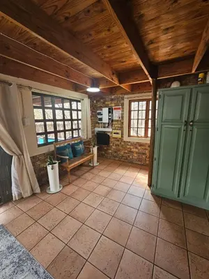 a large room with green cabinets and a tiled floor at Inkwazi Place in Marloth Park