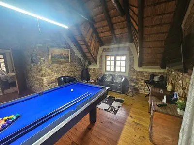 a pool table in a room with a brick wall at Inkwazi Place in Marloth Park