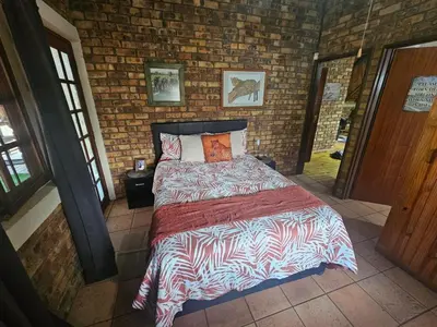 a bedroom with a bed in a brick wall at Inkwazi Place in Marloth Park