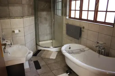 a bathroom with a tub and a toilet and a sink at Wilgeboomsdrift Safaris in Modimolle