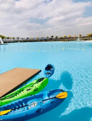 a swimming pool with two canoes in the water at The Blyde Riverwalk estate, Crystal Lagoon in Pretoria
