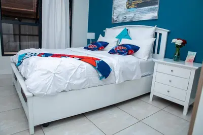 a bedroom with a white bed with blue walls at The Blyde Riverwalk estate, Crystal Lagoon in Pretoria