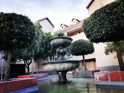 a fountain in the middle of a courtyard with trees at Hatfield, Grosvenor Private apartment. in Pretoria