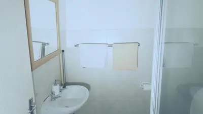 a white bathroom with a sink and a shower at Hatfield, Grosvenor Private apartment. in Pretoria