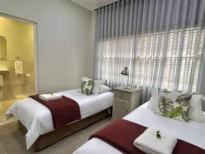 a bedroom with two beds and a window at Le Rendezvous in Dullstroom