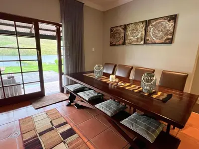 a dining room with a wooden table and chairs at Le Rendezvous in Dullstroom
