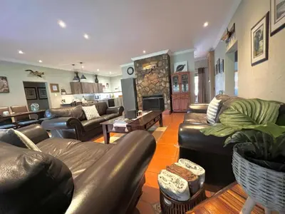 a living room with leather furniture and a fireplace at Le Rendezvous in Dullstroom