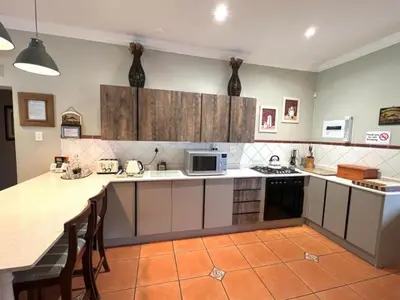 a kitchen with white cabinets and a counter top at Le Rendezvous in Dullstroom