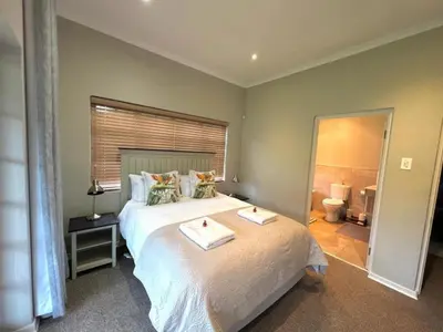 a bedroom with a large bed with two trays on it at Le Rendezvous in Dullstroom