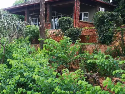 a garden in front of a brick house at Metsing at Harties in Hartbeespoort
