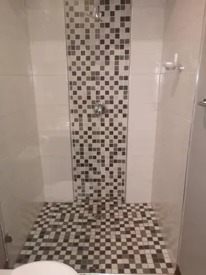 a bathroom with a shower with a black and white tiled floor at Metsing at Harties in Hartbeespoort