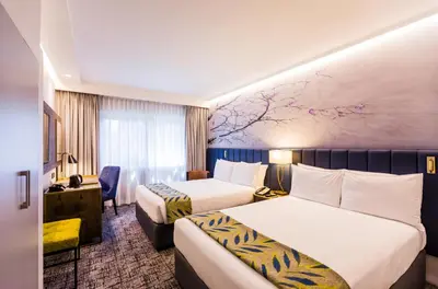 a hotel room with two beds and a desk at Garden Court Hatfield in Pretoria