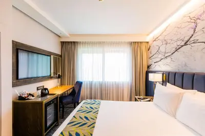 a hotel room with a bed and a desk at Garden Court Hatfield in Pretoria