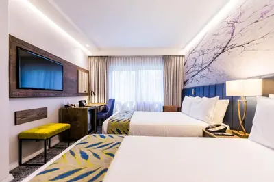 a hotel room with two beds and a flat screen tv at Garden Court Hatfield in Pretoria