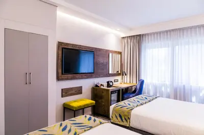 a hotel room with two beds and a tv at Garden Court Hatfield in Pretoria