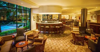 a hotel lobby with a bar and a pool at Garden Court Hatfield in Pretoria
