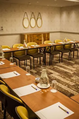 a conference room with wooden tables and chairs at Garden Court Polokwane in Polokwane