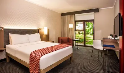 a hotel room with a bed and a desk at Garden Court Polokwane in Polokwane